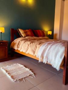 a bedroom with a bed with a rug on the floor at Camiare Aparts in Villa General Belgrano