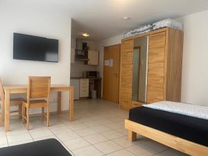 a bedroom with a bed and a desk and a television at Boardinghouse Casita Amann in Friedrichshafen