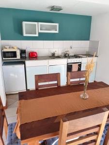 a kitchen with a wooden table with chairs and a table sidx sidx at Camiare Aparts in Villa General Belgrano