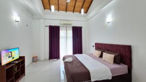 a bedroom with a bed and a television in it at Haven Stay in Sri Jayewardenepura Kotte