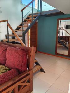 a living room with a staircase and a couch at Camiare Aparts in Villa General Belgrano +5 photos