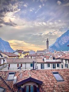 a view of a town with roofs and a clock tower at Casa Il Nido Bright Rooftop Nest in Lecco