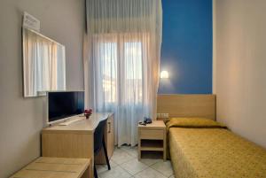 a bedroom with a bed and a desk and a television at Albergo La Posta Arezzo in Badia Al Pino