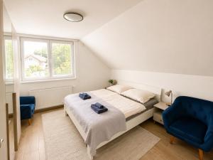 a bedroom with a bed and a blue chair at Elysian apartment 1 in Trenčín