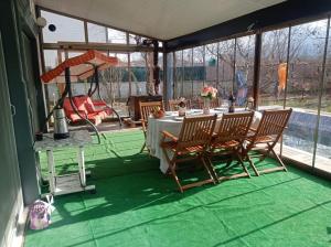 a screened in porch with a table and chairs at Villa Yazır in Antalya