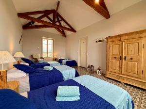 a bedroom with three beds and a wooden cabinet at La Belle Eclusière in Homps