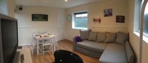 ein Wohnzimmer mit einem Sofa und einem Tisch in der Unterkunft Ty Mynydd Lodge Holiday Home in Cardiff