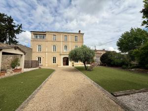 a large house with a grass yard in front of it at La Belle Eclusière in Homps