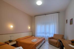 a hotel room with two beds and a chair at Albergo La Posta Arezzo in Badia Al Pino