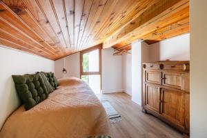 a bedroom with a bed and a wooden ceiling at Petit Clos d'Hélix in Annay-sur-Serein