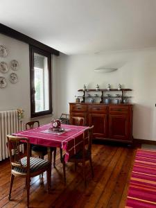 a dining room with a table and a kitchen at Storico appartamento con parco in Sanguinetto