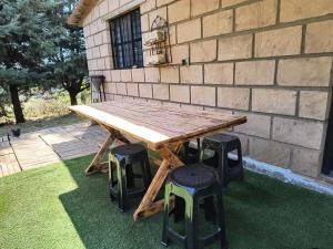a wooden table and stools in front of a building at Cabaña Metztli in Amealco