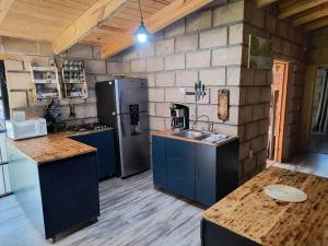 a kitchen with blue cabinets and a refrigerator at Cabaña Metztli in Amealco