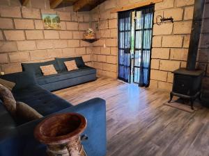 a living room with a couch and a wood stove at Cabaña Metztli in Amealco