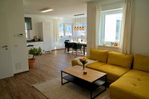 a living room with a yellow couch and a table at Dangos Mountainview Gosau in Gosau