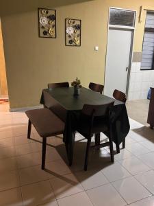 a black dining room table and chairs in a room at klebang Beachfront Homestay I Snooker I Massage Chair I Pool in Malacca