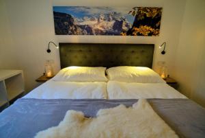 a bedroom with a bed with white sheets and pillows at Dangos Mountainview Gosau in Gosau
