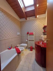 a bathroom with a tub and a toilet and a sink at Casina Rossa in Ballabio +41 photos