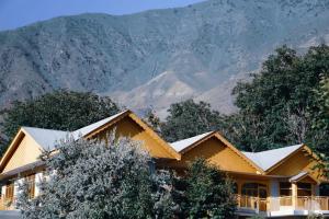 a house covered in snow with mountains in the background at Comfort Inn in Chitral