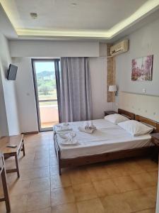 a bedroom with a large bed and a large window at Vera Studios in Faliraki