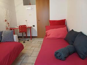 a bedroom with a red bed with a stuffed animal on it at Casina Rossa in Ballabio