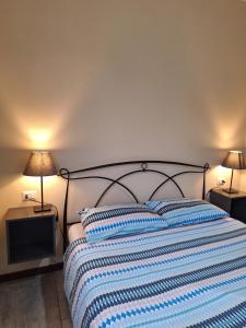 a bed with a blue and white striped blanket and two lamps at B&B near Lake Como - Close to train & bus - Breakfast included in Valmadrera