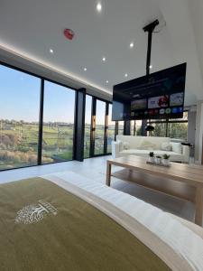 a living room with a large tv and a couch at Woodroyd Spa Suites in Luddenden Foot