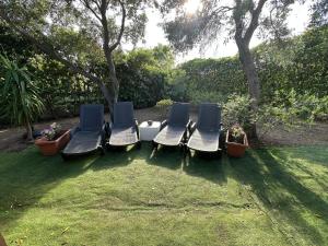 a group of chairs sitting on the grass at Villetta il caminetto in Geremèas