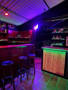 a bar with purple lights and stools in a room at Escapada En La Quinta Esperanza in Sasaima
