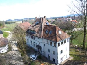 eine Luftansicht eines großen weißen Hauses mit rotem Dach in der Unterkunft Altes Schulhaus in Argenbühl