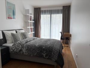 a bedroom with a bed and a large window at Studio de standing in Malakoff