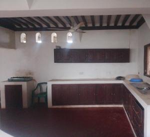 a kitchen with wooden cabinets and a counter top at Magram House in Lamu