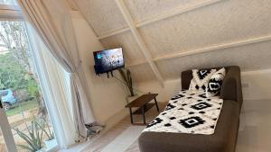 a living room with a couch and a tv at Cabin Mattias in Coron