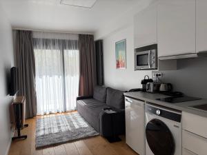 a small living room with a couch and a kitchen at Studio de standing in Malakoff
