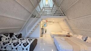 a attic room with two beds and a staircase at Cabin Mattias in Coron