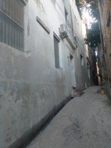 an alleyway with a white building and a street at Magram House in Lamu