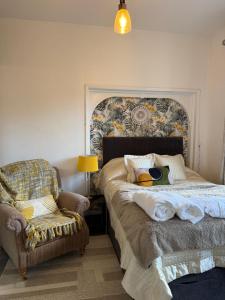 a bedroom with a bed and a chair at Sunshine apartment in Maidstone