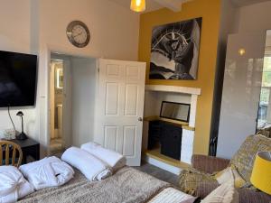 a living room with a couch and a clock on the wall at Sunshine apartment in Maidstone +3 photos