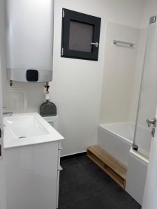 a white bathroom with a sink and a shower at Studio de standing in Malakoff