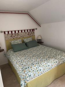 a bedroom with a bed with a floral bedspread at La Petite Bergère in Saint-Méloir-des-Ondes +9 photos