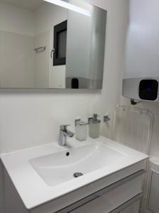 a bathroom with a white sink and a mirror at Studio de standing in Malakoff