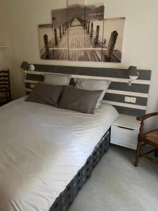 a bedroom with a bed with a picture of a pier at La Petite Bergère in Saint-Méloir-des-Ondes