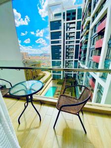 a balcony with two tables and chairs on a building at Nairobi Comfort Suites in Nairobi