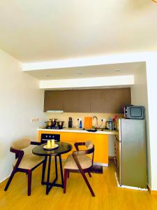 a kitchen with a table and chairs and a refrigerator at Nairobi Comfort Suites in Nairobi