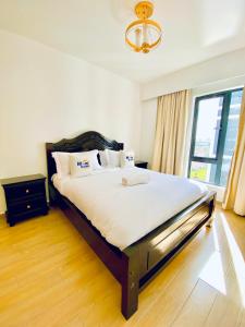 a bedroom with a large bed with white sheets and a window at Nairobi Comfort Suites in Nairobi +8 photos