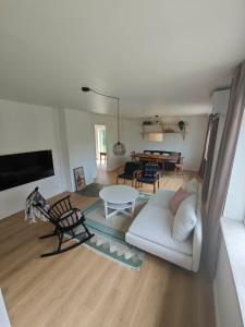 a living room with a white couch and a table at The Green House Holiday Home in Tomelilla