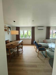 a living room with a table and a couch at The Green House Holiday Home in Tomelilla +20 photos