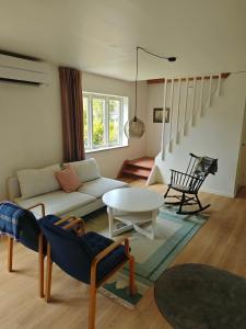 a living room with a couch and a table at The Green House Holiday Home in Tomelilla