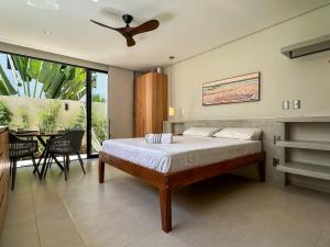 a bedroom with a bed with a ceiling fan at Chalé by Vila Manga Rosa in Pipa