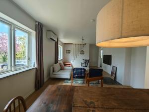 a living room with a table and a couch at The Green House Holiday Home in Tomelilla